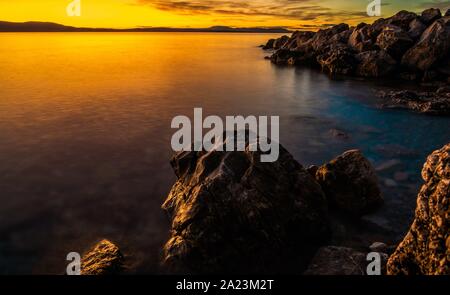 Malerische Adria Sonnenuntergang mit Felsen formationen am Strand. Bunten Abend. Stockfoto