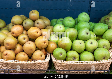 Gelbe und grüne Birnen auf einem Regal der Kühlschrank, in einem Supermarkt. Stockfoto