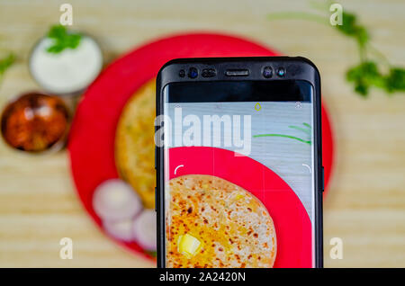 Schießen von aloo Paratha mit einem Mobiltelefon Stockfoto