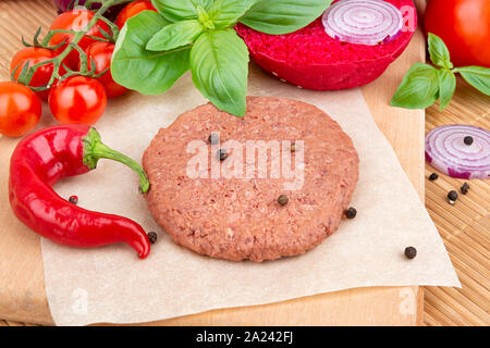 Vegane Burger Kochen mit rohem Soja Fleisch Schnitzel, Gewürze und Gemüse Stockfoto