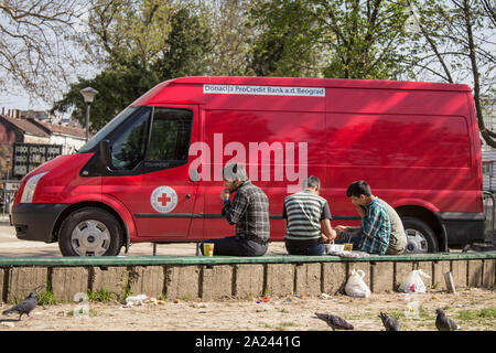 Belgrad, SERBIEN - April 2, 2016: Flüchtlinge aus Syrien und Afghanistan essen vor einer humanitären Rote Kreuz Van Truck, auf dem Balkan Route, dur Stockfoto