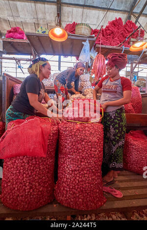 Frauen beschäftigt, Sortieren und den Verkauf von roten Zwiebeln in der gemüseabteilung am alten, lokalen, traditionellen Markt, Pasar Pabean. Im arabischen Viertel Abschnitt Stockfoto