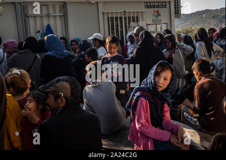 Athen, Griechenland. 26 Sep, 2019. Migranten sitzen in einem provisorischen Lager neben dem Moria Camp auf der Insel Lesbos. Fünf Inseln der östlichen Ägäis tragen die Hauptlast der Flüchtlinge Abkommen zwischen der EU und der Türkei. Credit: Angelos Tzortzinis/dpa/Alamy leben Nachrichten Stockfoto