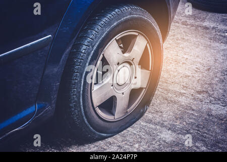 In der Nähe von flachen hinteren Reifen eines Autos durch Schraube beschädigt Stockfoto