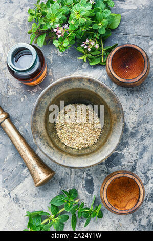 Oregano oder majoran Blätter in Mörtel. Bündel Heilkräuter. Flach Stockfoto