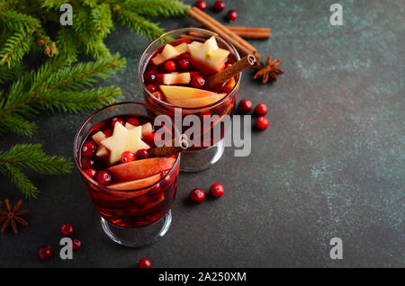 Weihnachten Glühwein mit Apfel, Orange und Preiselbeeren. Urlaub Konzept dekoriert mit Tannenzweigen, Preiselbeeren und Gewürzen. Stockfoto
