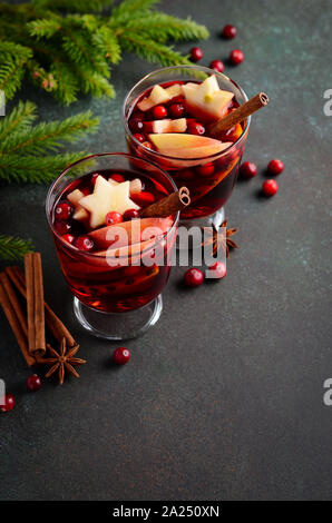 Weihnachten Glühwein mit Apfel, Orange und Preiselbeeren. Urlaub Konzept dekoriert mit Tannenzweigen, Preiselbeeren und Gewürzen. Stockfoto