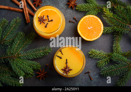 Herbst Winter Cocktail Hot Spicy Orange Punch mit Gewürzen. Urlaub Konzept dekoriert mit Tannenzweigen und Gewürzen. Stockfoto