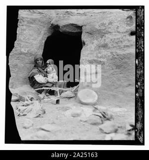 Petrean Typen, etc. Petra. Bdul Höhlenwohnungen Araber. Mutter und Baby vor ihrer Höhle in ed-Der Tal Stockfoto