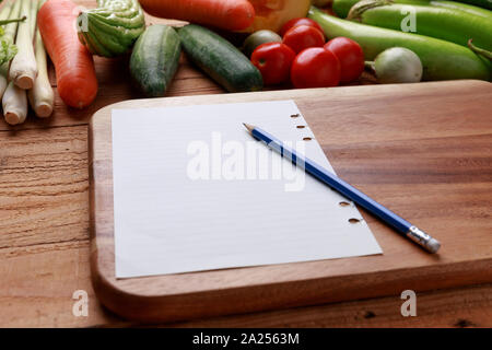 Thailändische Küche. Verschiedene Gemüse, Gewürze und Zutaten mit leeren Notizbuch und Bleistift auf Holz- Hintergrund. Stockfoto