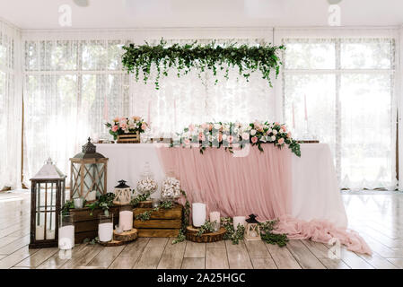 Schönen Bräutigam und Braut Tabelle in der Nähe von große, helle Fenster mit natürlichen Materialien eingerichtet Stockfoto