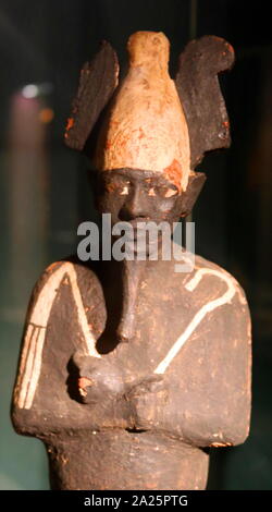 18. Dynastie Holz- grabkunst Statue von Osiris, der Gott der Fruchtbarkeit, Alkohol, Landwirtschaft, das Leben nach dem Tod, die Toten, Auferstehung, Leben und Vegetation in alten ägyptischen Religion. Er war klassisch als Grünhäutigen Gottheit mit einem Pharao Bart, teilweise Mumie - auf die Beine gewickelt, das Tragen eines unverwechselbaren atef Krone, und halten einen symbolischen Crook und dreschflegel dargestellt Stockfoto