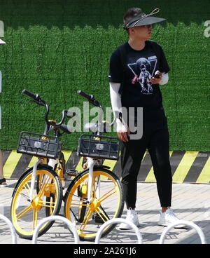 Junge Radfahrer Buch vermietet city Fahrräder in Peking mit Booking ihre Mobiltelefone. Stockfoto