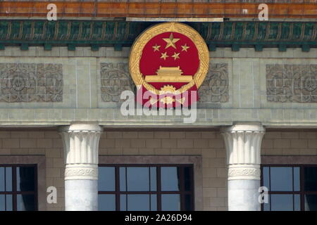 Der chinesische Staat Wappen über dem Eingang der Großen Halle des Volkes, Peking, China. Die fünf Sterne auf das Emblem haben die gleiche Bedeutung wie die auf der nationalen Flagge. Das Goldene Zahnrad steht für die Arbeitnehmer. Der Weizen stellt die Bauern. Die Verbindung von ihnen repräsentiert die Worker-Peasant Bündnis unter Führung der Arbeiterklasse in China. Stockfoto