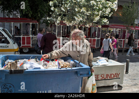 Athen, Griechenland, Juni 04, 2016. Bettler überprüfen Sie den Inhalt der Container im Zentrum von Athen. Stockfoto