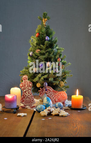 Weihnachtsbaum mit Lebkuchen Santa und Pferd, Kerzen, verzierte Eier auf den Tisch Stockfoto