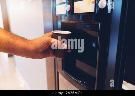 Hand mit Kaffee, Getränkeautomat, Kaffeemaschine Stockfoto