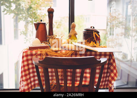 Set aus Holz und Stahl Couchtisch und Stühlen mit weißer Keramik Vase und bunten Blumen außerhalb der Coffee Shop in der industriellen Loft Style rot Bri Stockfoto