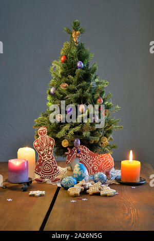 Weihnachtsbaum mit Lebkuchen Santa und Pferd, Kerzen, verzierte Eier auf den Tisch Stockfoto