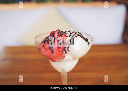 Hohen Winkel noch Leben von Dessert Eisbecher mit neapolitanischen Eissorten - Glas Schale mit Schaufeln von Schokolade, Vanille und Erdbeere Eis w Stockfoto