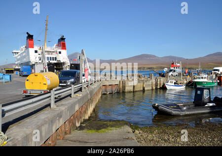 MV Finlaggan, ein Caledonian MacBrayne Island Fähre bei Port Askaig Auf der schottischen Insel Islay. Die Hügel von Jura kann im Hintergrund gesehen werden. Stockfoto