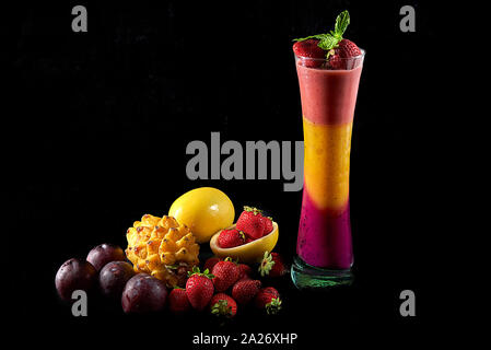 Dragon Obst, Passionsfrucht und Erdbeer Mousse. Von frischen Früchten begleitet: dragon Obst, Passionsfrucht, Erdbeeren und rote Pflaumen. Schwarz backgro Stockfoto