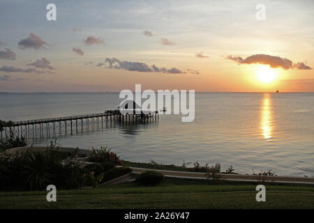 Blick auf den Pier mit einem Lapa Bar am Strand und Blumenbeet mit Rasen bei Sonnenuntergang, vor der Küste von Sansibar, Unguja Insel, Tansania. Stockfoto