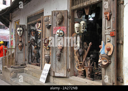 Afrikanische Holzmasken, woen Statuen und andere Holz- Afrikanische Produkte im Shop verkauft, Stone Town, Sansibar, Unguja Insel, Tansania. Stockfoto