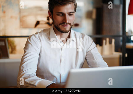 Gut aussehend Geschäftsmann arbeiten mit Laptop im Büro Stockfoto