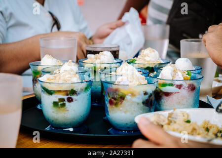 Familie essen mit bestellt sieben Portionen des populären und beliebten Filipino kaltes Dessert Halo-halo (auch buchstabiertes haluhalo). Selektive konzentrieren. Stockfoto