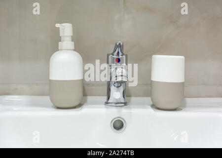 Seifen- und Shampoospender in der Nähe von keramischen Wasser Waschbecken mit Wasserhahn in teuren loft Bad tippen Stockfoto
