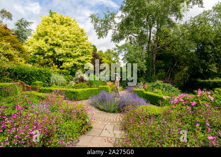 Die Betten der Rose Garten sind mit einer bunten Vielfalt von Stauden und Sträucher im Fuchsbau Bauerngärten, in der Nähe von Vina del Mar, Devon, England, UK gefüllt Stockfoto