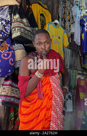 Lokalen Masai Anbieter vor kleidung shop, Stone Town, Sansibar, Unguja Insel, Tansania. Stockfoto