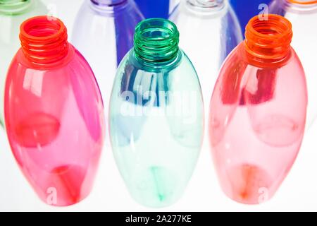 Farbigen Plastikflaschen syde durch syde auf eine durchscheinende Oberfläche Stockfoto