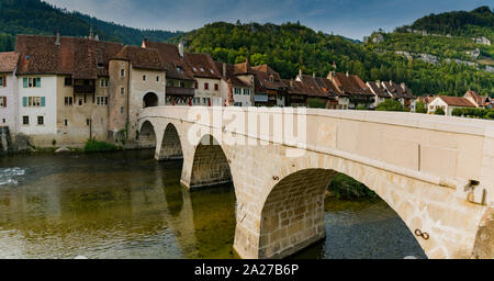 Saint-Ursanne, Jura/Schweiz - vom 27. August 2019: historische Steinbrücke führt zum Tor und malerischen Dorf Saint-Ursanne Stockfoto