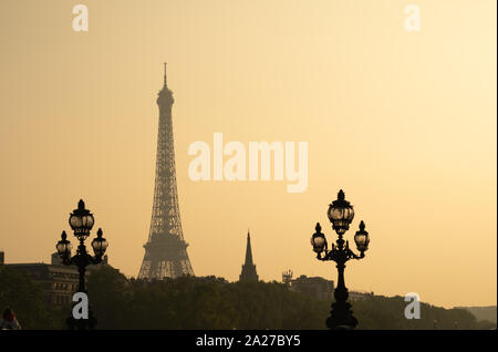 Statische Schuß von Alexandre III Bridge bei Sonnenuntergang in Paris. Eiffel Turm im Hintergrund Stockfoto