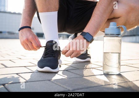 Junge männliche Läufer Vorbereitungen zu beginnen. Stockfoto