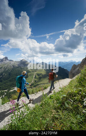 Bergführer und blonde Frau client Rückkehr von einem Aufstieg in den italienischen Dolomiten und Wandern auf einen Weg Stockfoto