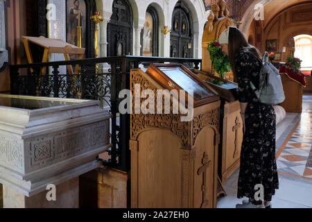 Eine russische christliche Pilger zu einem religiösen Symbol innerhalb der russisch-orthodoxen Kloster und die Kirche der Heiligen Maria Magdalena oder Maria Magdalena 1886 von Zar Alexander III. gebaut zu Ehren seiner Mutter, Kaiserin Maria Alexandrowna Russlands auf der Steigung der Ölberg in Ost-jerusalem Israel suchen Stockfoto