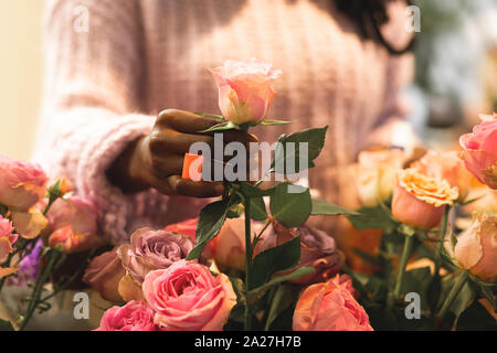 Riechen gut. Ausschreibung internationale Floristen tragen helle Ring während in floralen Boutique arbeiten Stockfoto