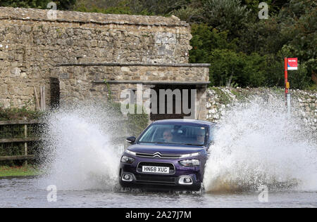 Beaulieu, New Forest, Hampshire. 1. Oktober 2019. UK Wetter: Hochwasser im Dorf von Beaulieu im New Forest nach dem Beaulieu River die Ufer bei Flut. Treiber ihren Weg durch das Hochwasser auf Palace Lane. Kredit Stuart Martin/Alamy leben Nachrichten Stockfoto