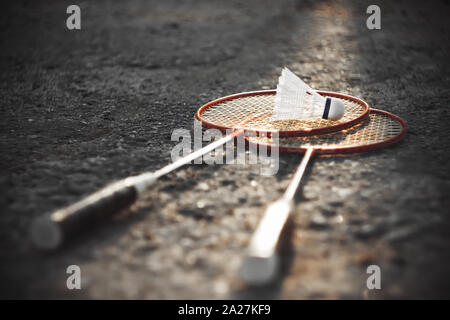 Schwarz-weiß-Bild, in dem eine helle rote Farbe Badminton Schläger und weißen Federball, die durch Sonnenlicht beleuchtet hervorgehoben. Stockfoto