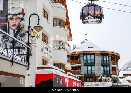 Ischgl, Österreich - 10. Januar 2018: Zentraler Platz der österreichischen alpinen Wintersportort Ischgl mit Hotels, Touristen und Silvretta bahn Ski-lift Stockfoto