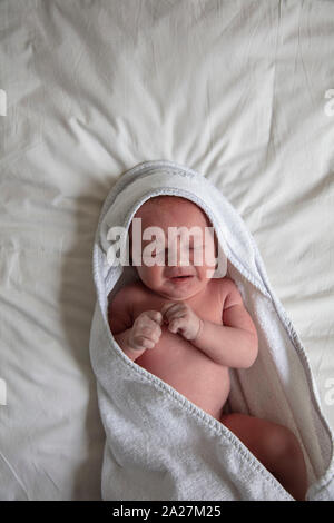 Ein schreiendes Baby in einer weißen Decke gewickelt Stockfoto