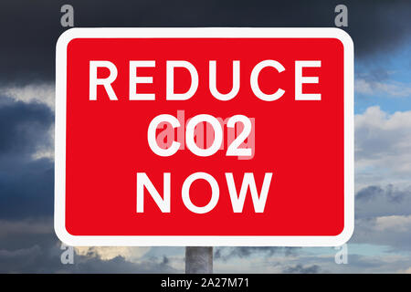 Klimawandel: CO2-Text jetzt auf roten und weißen Warnschild vor dunklen Himmel. Stockfoto