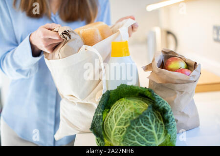 Nahaufnahme von Frau Heimweg von Shopping Trip Auspacken Lebensmittel in Kunststoff Free Packaging Stockfoto