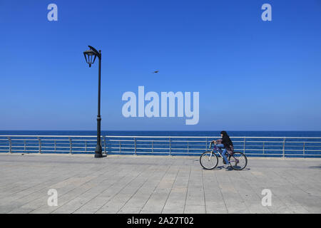 Beirut, Libanon. 1. Okt, 2019. Ein junges Mädchen mit Kopftuch reitet ihr Fahrrad entlang der Strandpromenade an einem heißen und sonnigen Herbsttag in der libanesischen Hauptstadt. Credit: Amer Ghazzal/SOPA Images/ZUMA Draht/Alamy leben Nachrichten Stockfoto