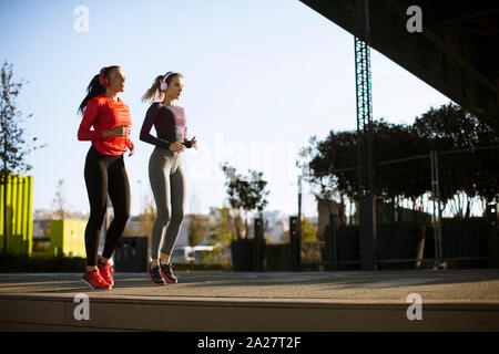 Landschaft von zwei weiblichen Jogger Verfolgung ihrer Aktivität in städtischen im Freien Stockfoto