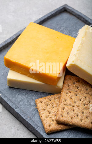 Käse Sammlung, gereift und orange original britischen Cheddar in Blöcke mit Crackers serviert Nahaufnahme Stockfoto