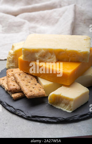 Käse Sammlung, gereift und orange original britischen Cheddar in Blöcke mit Crackers serviert Nahaufnahme Stockfoto